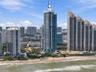 High-rise residential tower featuring a glass-facade exterior, private balconies, and an oceanfront location