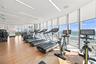 Fitness center featuring wood-finish flooring, floor-to-ceiling windows, and recessed linear lighting, with direct ocean backdrop