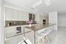Sleek kitchen featuring high-gloss cabinetry, stone-surface countertops, built-in wine refrigeration, stainless steel wall-mounted range hood, and pol