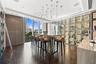 Custom temperature-controlled wine storage wall, floor-to-ceiling glass windows, wood-finish flooring, central island with quartz countertop, and mult