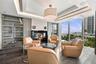 Floor-to-ceiling windows, wood-finish flooring, built-in display cabinetry, tray ceiling with recessed lighting, and a modern fireplace with a black g