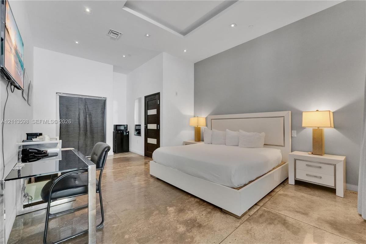 Tray ceiling with recessed lighting, polished stone flooring, and a multi-toned wood door with glass inserts