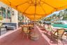 Outdoor terrace featuring a concrete patio, wall-mounted exterior lighting, and integrated booth seating