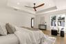 Primary bedroom with recessed ceiling and ceiling fan.