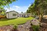 Landscaped backyard with mature trees and shrubs.