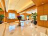 Grand lobby featuring polished stone flooring with decorative inlays, expansive wood-paneled walls, a vaulted ceiling, and a built-in recessed display