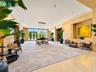 Expansive common area featuring stone-clad walls, recessed lighting, a modern multi-pendant chandelier, a built-in recessed display niche, and floor-t
