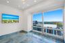 Floor-to-ceiling windows, blue-toned polished stone flooring, and recessed ceiling lighting