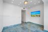 Polished blue stone flooring with gold veining, recessed ceiling lighting, and custom door casing