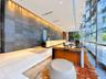 Grand lobby featuring a large-format textured stone feature wall, polished stone flooring, illuminated stone reception desk, and floor-to-ceiling glas