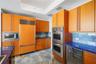 Kitchen featuring custom wood cabinetry, high-gloss blue countertops, stone tile flooring, integrated stainless steel appliances, and a built-in wine 