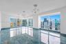 Polished blue-toned stone flooring, triple crystal chandeliers, floor-to-ceiling windows, and recessed lighting