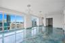 Polished stone flooring with blue and gold veining, floor-to-ceiling windows, three decorative crystal chandeliers with ceiling medallions, and recess