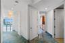 Polished stone flooring with blue and gold veining, multi-pendant dome light fixtures, solid-core interior doors, and floor-to-ceiling windows