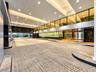 Covered motor court entrance featuring stone paver flooring, dark polished stone wall accents, extensive recessed lighting, and a glass-enclosed upper