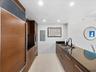 Kitchen featuring wood-finish cabinetry, built-in stainless steel appliances, dark stone countertops, undermount sink with a matte black faucet, and r