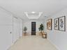 Interior space featuring large-format tile flooring, recessed ceiling lighting, a dedicated rectangular skylight, and multiple interior swing-style do