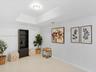 Neutral-toned room featuring a tray ceiling, recessed lighting, and polished stone-finish tile flooring