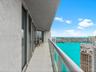 Balcony with large-format tile flooring, glass panel railing, and sliding glass door entry