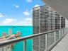 Balcony featuring glass panel railings and light-toned tile flooring