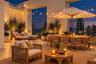 Expansive rooftop terrace featuring large-format tile flooring, perimeter structural pillars, and metal railings