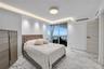 Floor-to-ceiling sliding glass doors, stone flooring with veining, recessed lighting, cove lighting, and a neutral wood-finish interior door