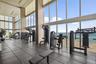 Fitness center featuring floor-to-ceiling windows, panoramic ocean scenery, and large-format tile flooring