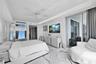 Stone flooring, tray ceiling with recessed lighting, floor-to-ceiling glass sliding doors, and ceiling fan