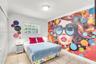 Room featuring large-scale wall mural, tiled flooring, multi-pane window, and double-door closet