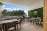 Covered outdoor terrace featuring natural stone tile flooring and a vertical greenery wall