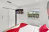 Recessed lighting, sliding closet doors, grid-pattern window, and neutral tile flooring