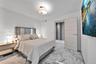 Stone-finish flooring, flush-mount lighting, and solid-core interior door with metallic hardware