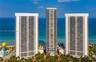 High-rise residential towers featuring glass-paneled balconies and direct oceanfront positioning