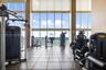 Fitness center featuring floor-to-ceiling windows, large-format tile flooring, and direct ocean exposure