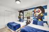 Room featuring large-format ceramic tile flooring, double-door closet with paneled detailing, dual-pane window with muntins, and a semi-flush mount ce