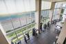 Fitness facility featuring double-height ceilings, floor-to-ceiling windows, ceramic tile flooring, and coastal scenery