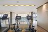 Fitness area featuring wood-finish flooring, recessed ceiling lighting, glass railings, and expansive windows with ocean scenery