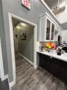 Two-tone cabinetry featuring white upper glass-front cupboards and dark lower base cabinets, complemented by white stone-surface countertops and wood-
