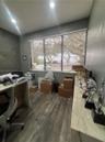 Room featuring wood-finish flooring, recessed lighting, and a long built-in stone-top counter with cabinetry
