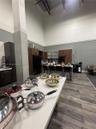 Kitchen featuring double-height ceilings, wood-finish cabinetry, a central island with quartz surfacing, and wood-finish flooring