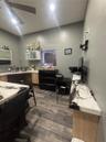 Room featuring wood-finish flooring, built-in cabinetry with light-toned wood base, stone countertops with distinctive veining, and a wall-mounted cei