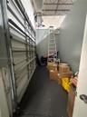 Storage area featuring exposed structural ceiling, metal roll-up door, and high-clearance vertical wall space