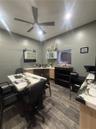 Wood-finish flooring, custom built-in cabinetry with stone-finish countertops, and a modern ceiling fan