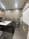 Large-format grey tile flooring, geometric wall pattern, and recessed ceiling lighting