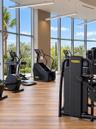 Fitness center featuring floor-to-ceiling windows, wood-finish flooring, and recessed linear pendant lighting
