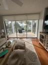 Spacious living area featuring expansive sliding glass doors opening to a private balcony