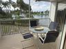 Screened balcony with lake frontage and tropical landscaping