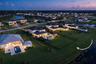 Aerial perspective of a sprawling property featuring a vast manicured lawn, an expansive rear lot boundary, and direct waterfront access