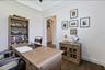 Room featuring tray ceilings, wood-finish flooring, and an arched doorway