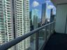 Covered balcony featuring square interlocking floor tiles and a full-height glass railing with a metallic handrail
